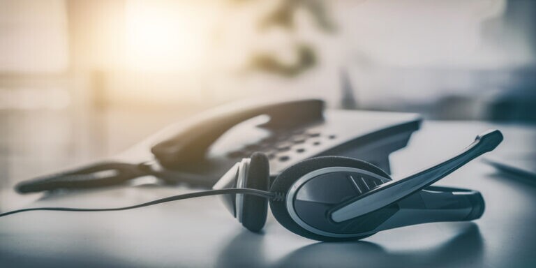 Call center headset on desk representing IT help desk support tools
