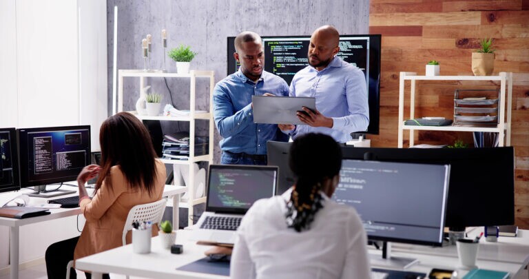 African business team collaborating on software app development discussing project details in a modern office setting
