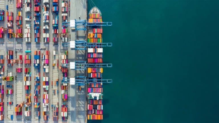 Aerial view of a busy shipping port with colorful containers stacked and cranes ready for loading highlighting logistics efficiency related to Kubernetes