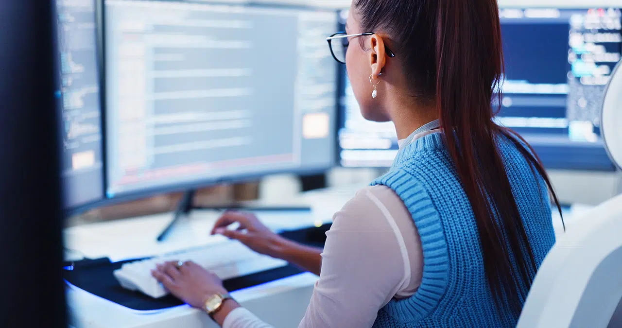 Engineer reviewing code and patch management strategy dashboards to schedule patch frequency
