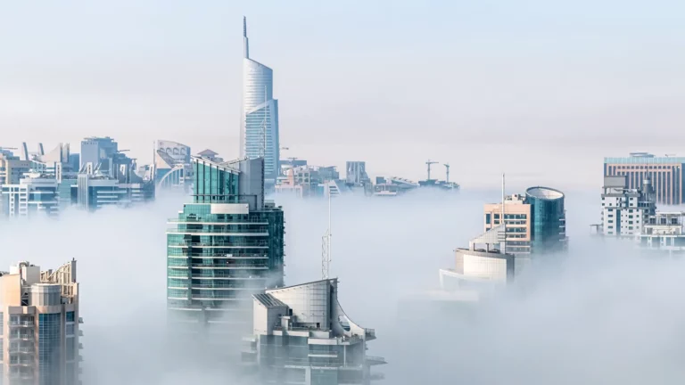 Modern city skyline emerging from fog highlighting the advantages of cloud computing for urban development and business innovation