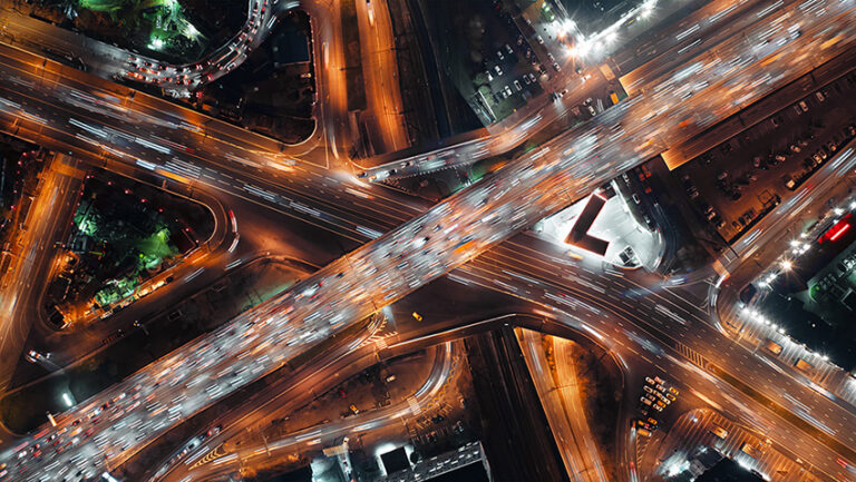 Aerial view of busy highway with fast moving cars showcasing intense traffic patterns symbolizing efficient automation in transportation