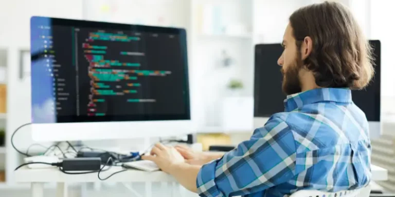 Software engineer coding at desktop illustrating DevOps skills shortage in the tech industry