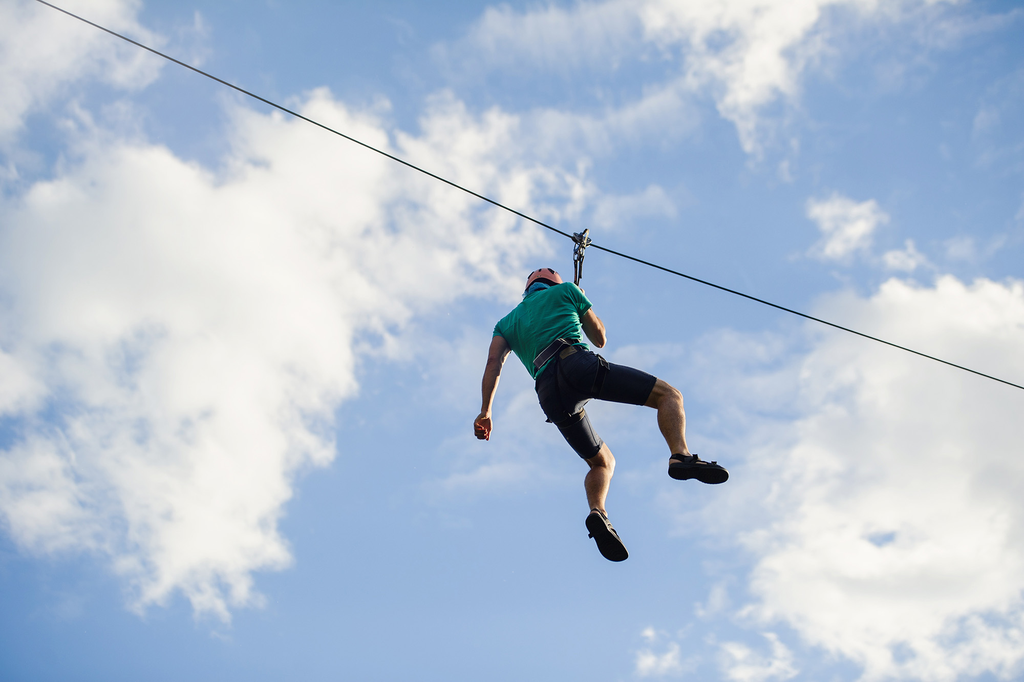 Man ziplining through the sky symbolizing challenges and risks in cloud migration processes