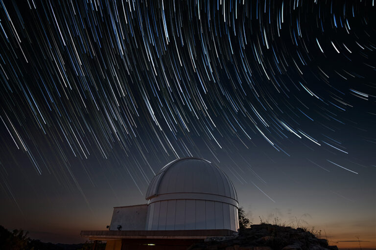 Astronomical observatory under a starry sky with star trails showcasing the beauty of night skies in digital transformation context