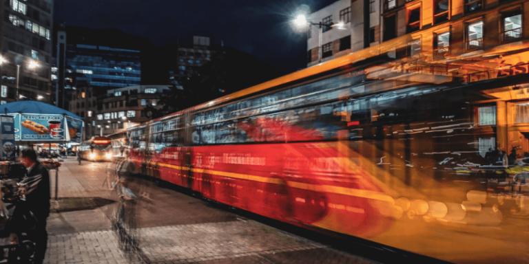 Blurred motion of a bus in a city symbolizing the fast paced software development industry