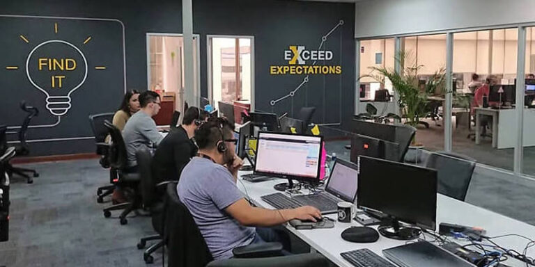 Modern IT help desk environment with staff using computers and headsets promoting improved performance and client support