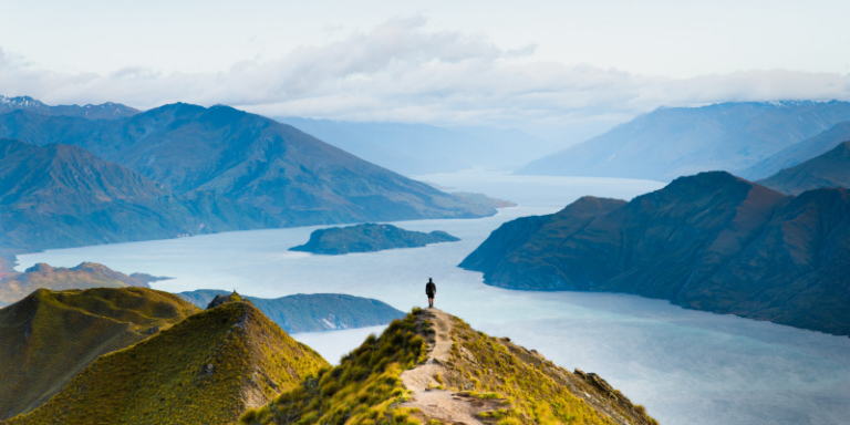 Person hiking along a mountain ridge with panoramic view symbolizing analytics journey