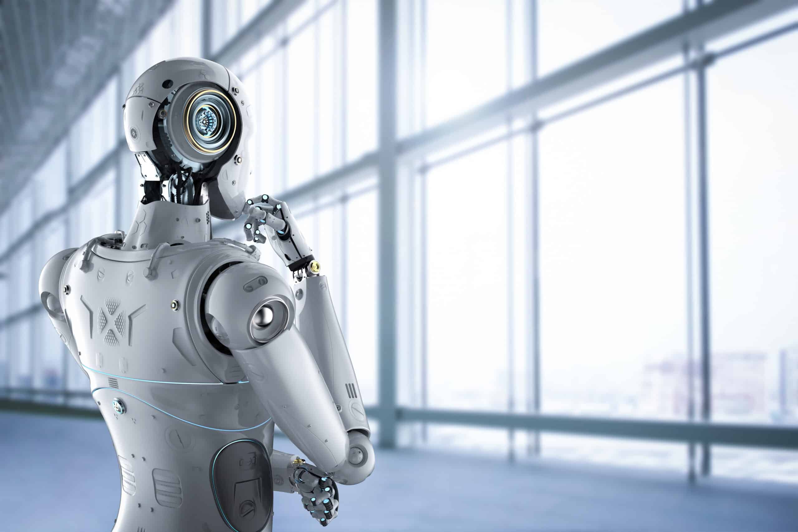 A humanoid robot gazes thoughtfully out of a modern office window symbolizing the impact of RPA and AI on the future of work