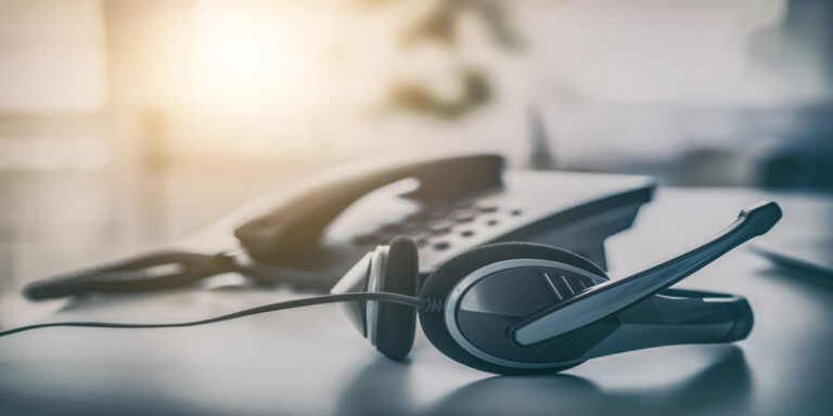 Call center headset on desk representing IT help desk support tools