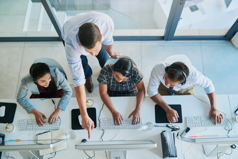 Overhead view of an HR help desk team working at computer workstations