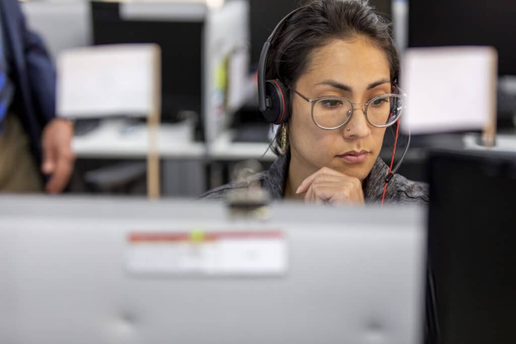 Worker in an office, in front of a monitor and wearing headphones, focused on her daily activity.