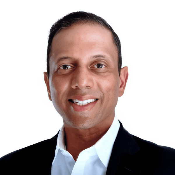 Professional headshot featuring a smiling man in a suit, conveying confidence and approachability in a business context.
