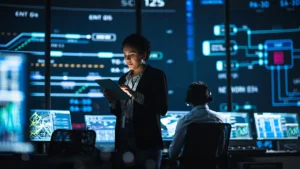 Woman working in cybersecurity at a technology operations center with multiple screens