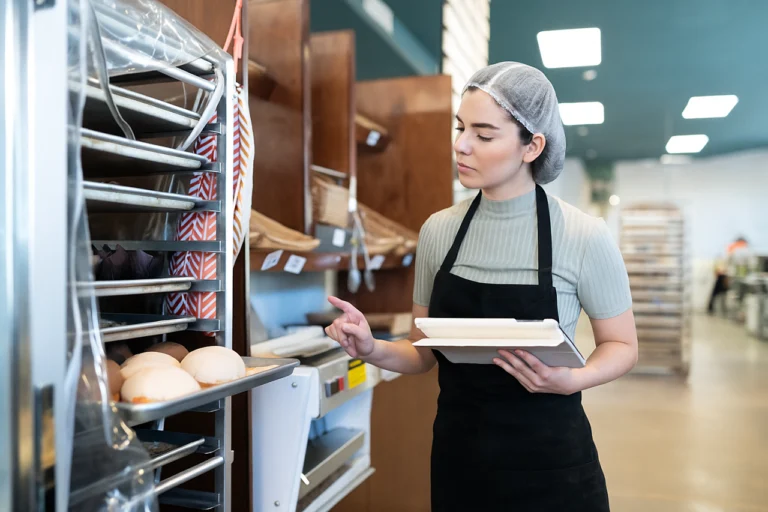 Bakery employee conducting a food safety audit with a checklist to ensure food safety compliance and quality assurance