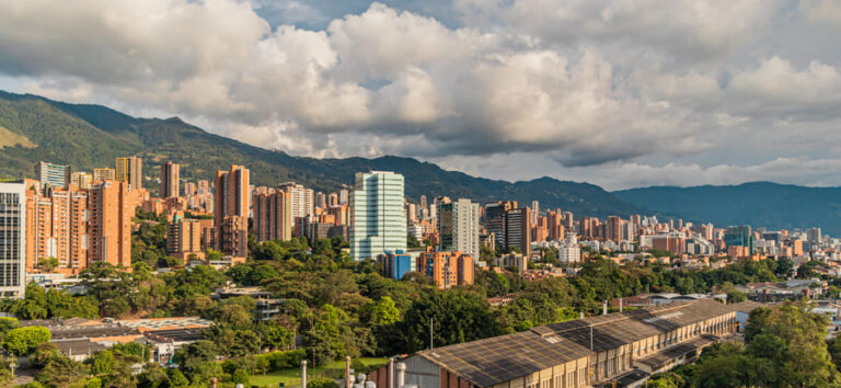 A panoramic view of Medellíns skyline showcasing modern architecture against a backdrop of lush mountains