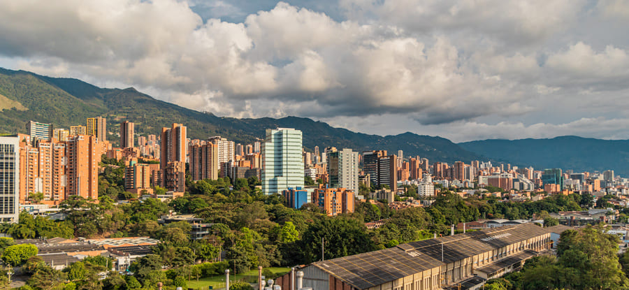 A panoramic view of Medellíns skyline showcasing modern architecture against a backdrop of lush mountains