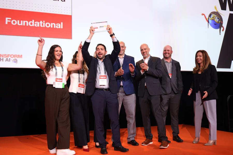 Team celebrates a significant achievement at the Transforming AI event showcasing their award for foundational innovation