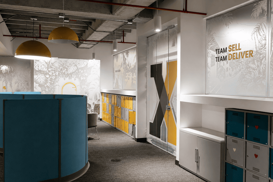 Modern office space featuring vibrant colors, collaborative areas, and motivational team slogans promoting productivity.