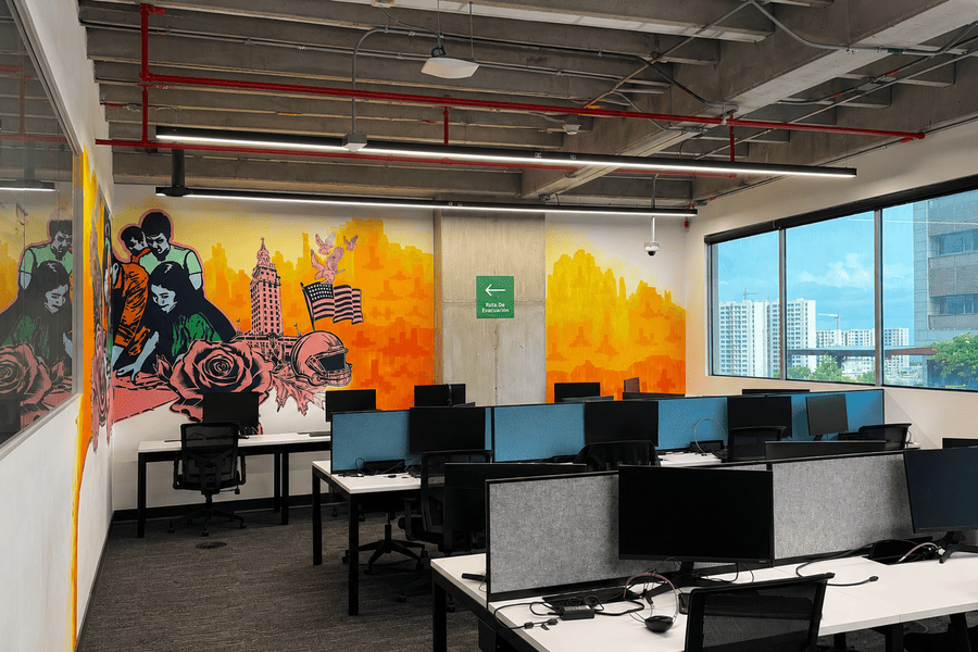 Vibrant office space featuring modern workstations and colorful wall art, promoting creativity and collaboration in a dynamic environment.