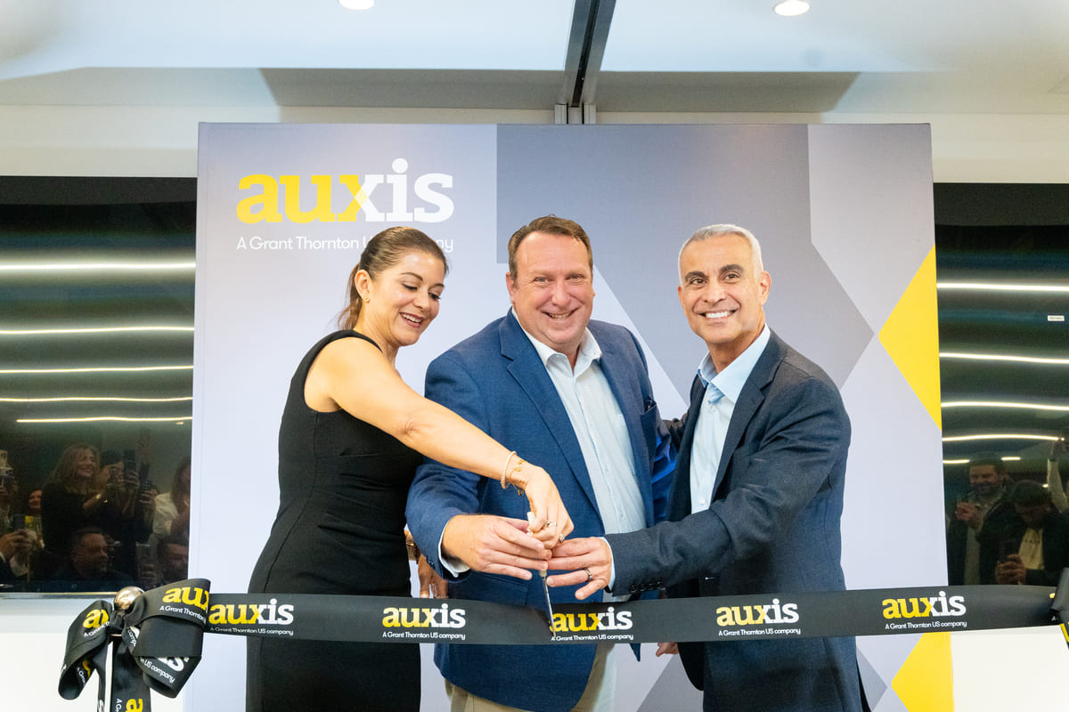 Auxis executives celebrate growth in Colombia by cutting the ribbon marking the hiring of over 500 bilingual professionals