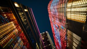 Vibrant cityscape at night showcasing modern architecture with colorful illuminated facades reflecting urban innovation
