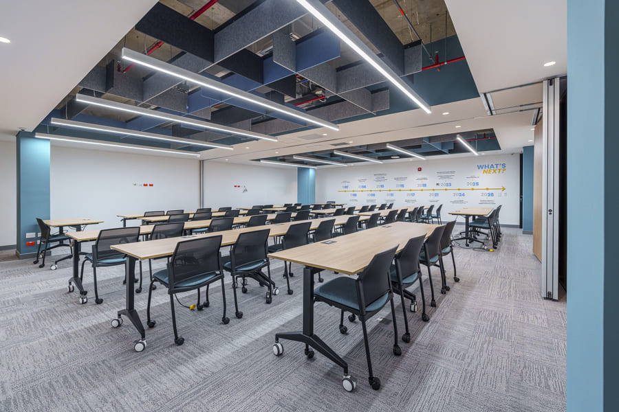 Modern conference room featuring movable tables and chairs, designed for collaborative meetings and presentations.