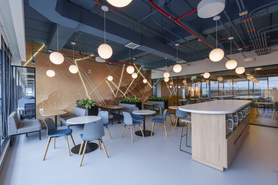 Modern office space featuring stylish furniture, ambient lighting, and greenery for a productive work environment.