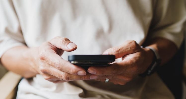 Close up of person looking at mobile phone, Online social addict.