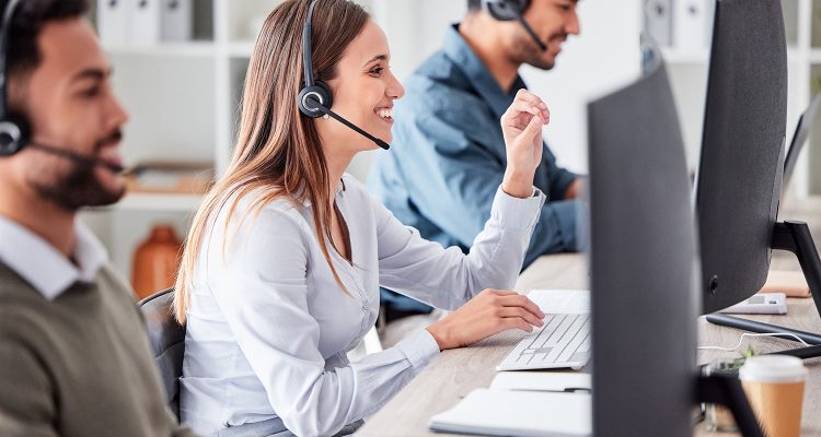 Call center, woman and working in team office with headset, computer and online customer support, service or help. Businesswoman, smile and contact us, crm and telemarketing employee talking.