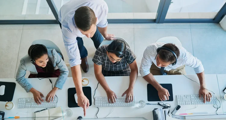 Overhead view of an HR help desk team working at computer workstations.