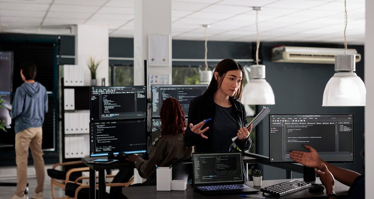 Database web developers developing source code and cloud computing in it big data office room. African american programmer typing on keyboard to create artificial intelligence script.