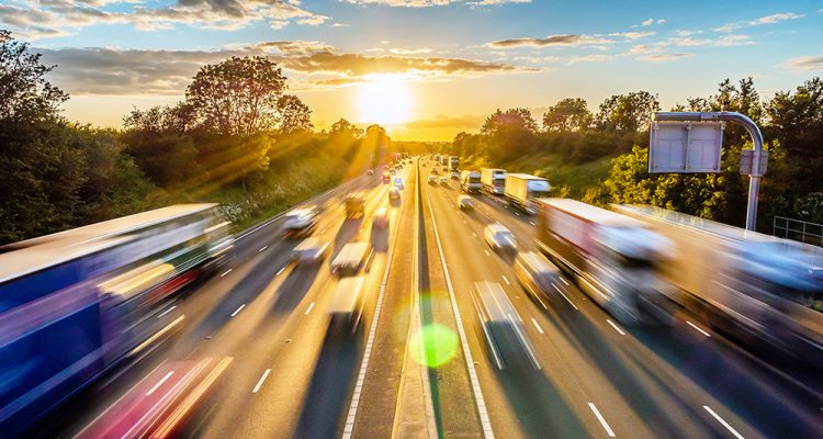 heavy traffic moving at speed on UK motorway in England at sunset.