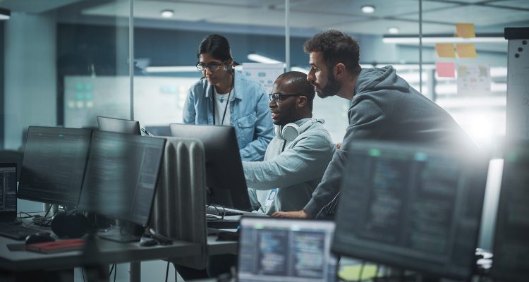 Diverse Group of Professionals Meeting in Modern Office: Brainstorming IT Programmers Use Computer Together, Talk Strategy, Discuss Planning. Software Engineers Develop Inspirational App Program